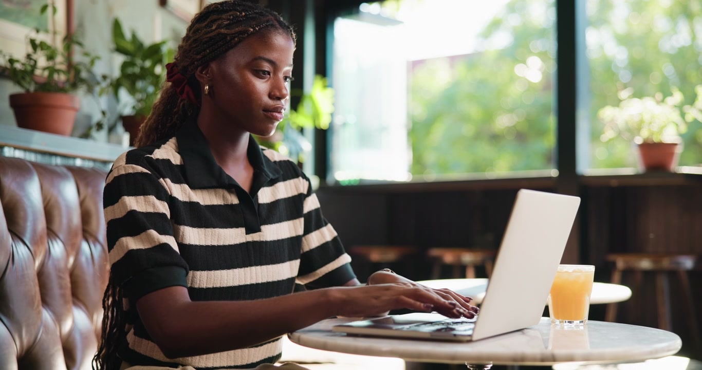 Young Woman Working on Laptop in a Cafe