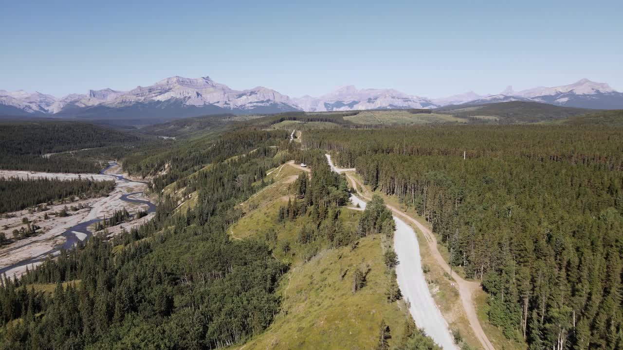 vasto e interminable bosque de coníferas con un telón de fondo de montañas rocosas en un día soleado en canadá