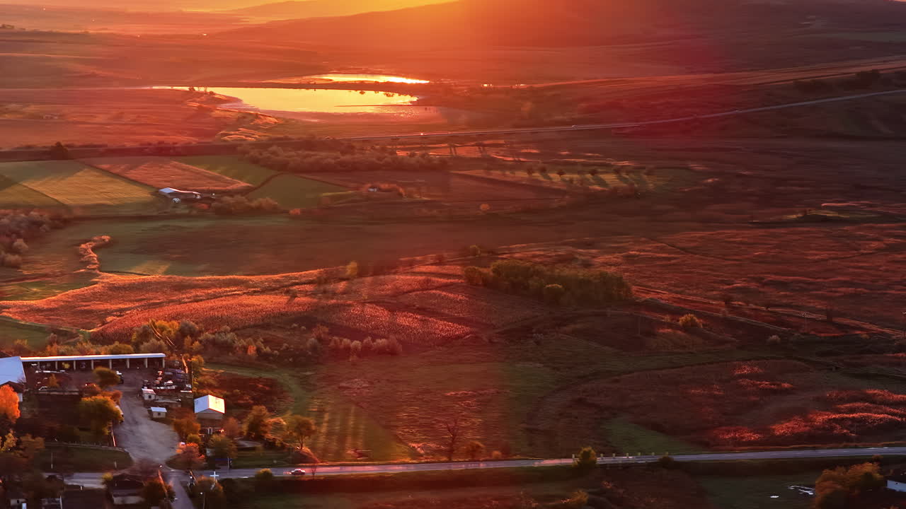Aerial drone view of a car driving along a countryside road in Moldova during golden hour