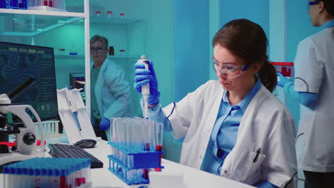 enfermera científica que utiliza una micropipeta para llenar tubos de ensayo
