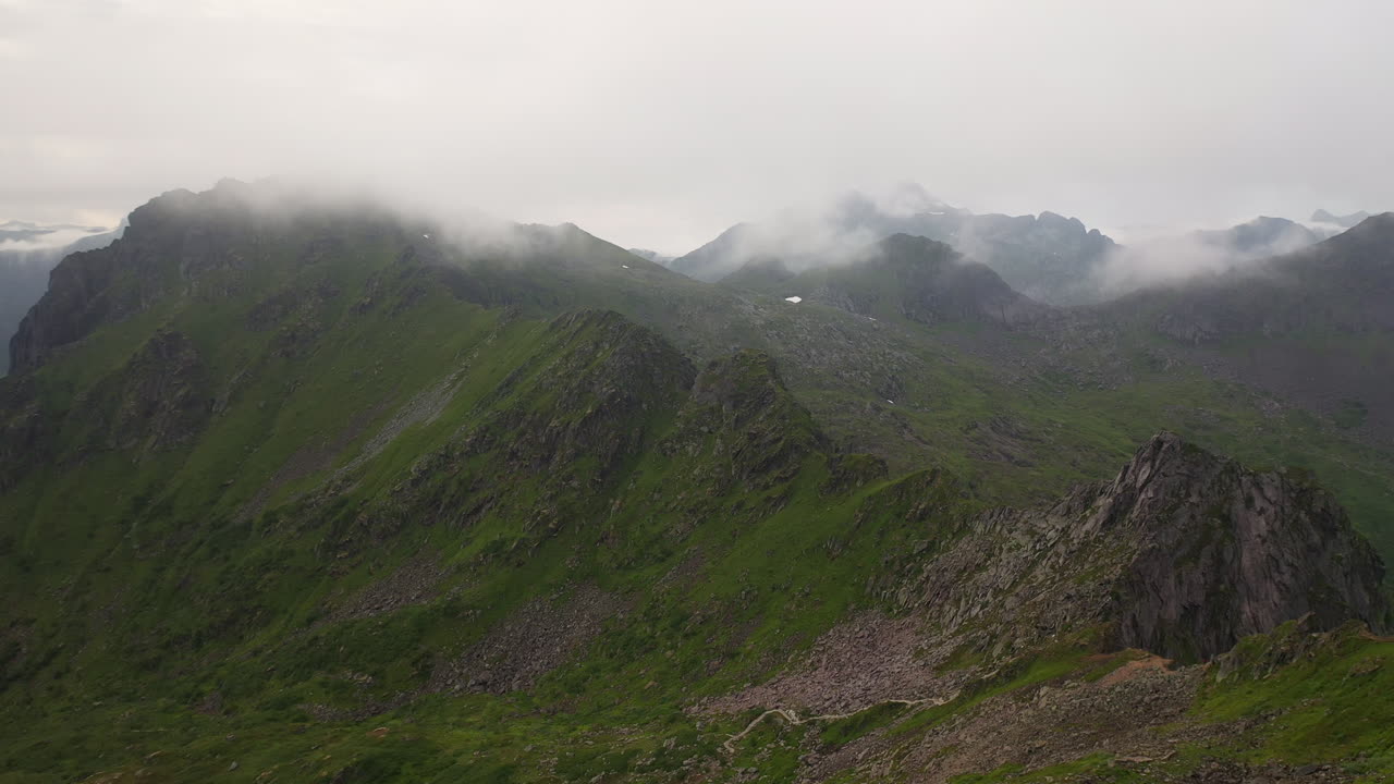 Drone shot flying over mountain ridges, Fl&oslash;ya and Djevelporten above Svolv&aelig;r in Lofoten, Norway, aerial footage