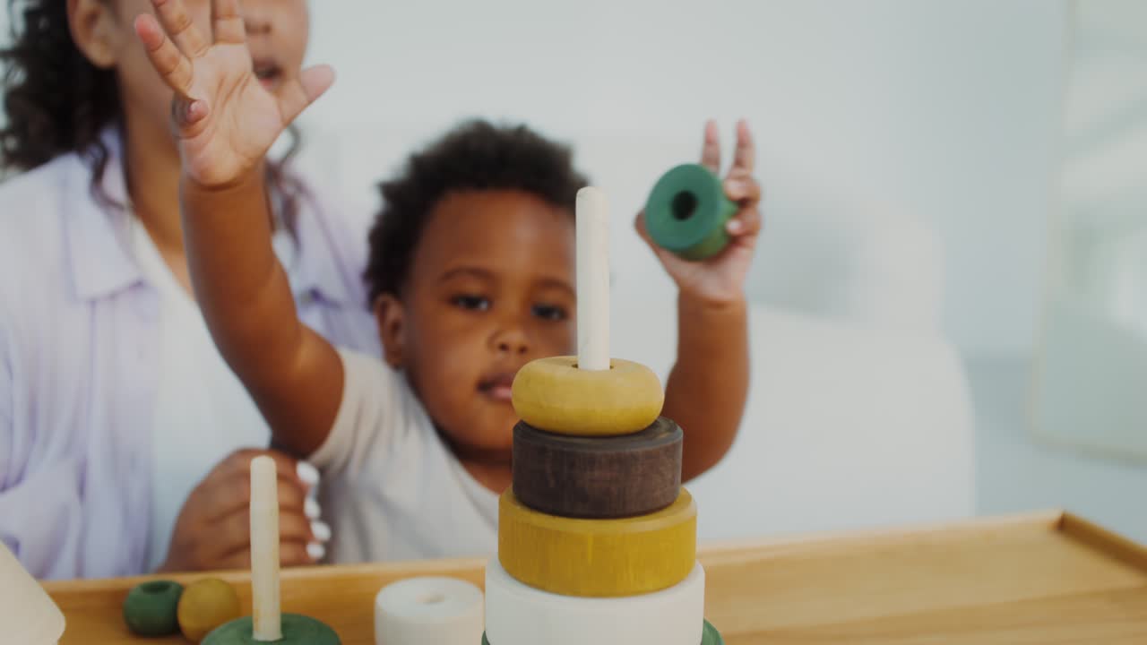 Mother and child playing with stacking rings toy