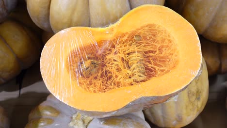 close-up of a cut pumpkin wrapped in plastic wrap