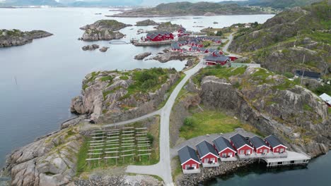 lofoten islands red cabins 'rorbuer' in mortsund fishing village, norway - aerial 4k tilting up