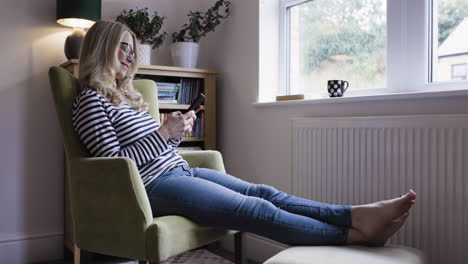 woman sitting in a chair using her phone