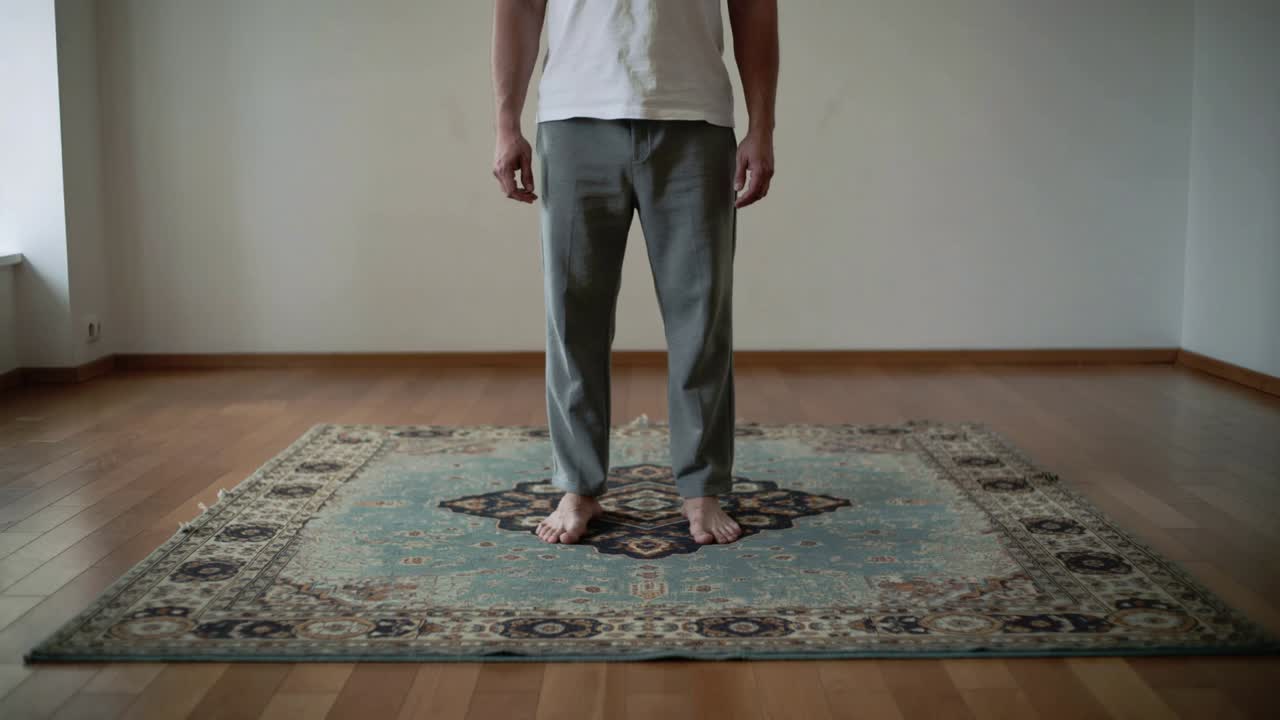 Registrazione di un uomo adulto che sposta il peso, in equilibrio su un tappeto fantasia, indossando una camicia bianca