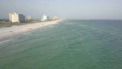 tourists relaxing on the shore at orange beach alabama on a cloudy day - aerial drone shot