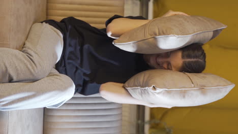 Vertical-video-of-The-young-woman-who-presses-the-pillows-on-her-head-with-fear.