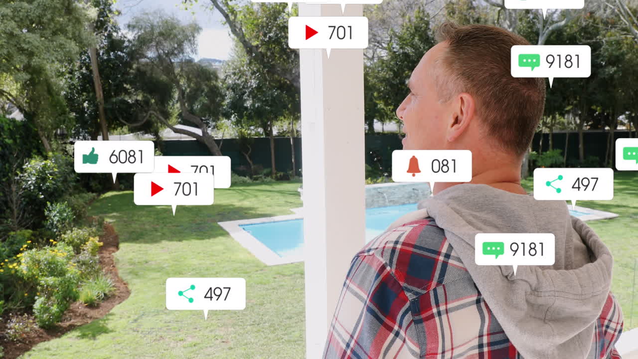 소셜 미디어 아이콘의 애니메이션이 집의 verandah에 서있는 백인 남자를 떠다니고 있습니다.