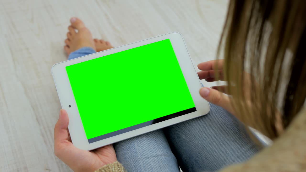 mujer mirando una tableta con pantalla verde