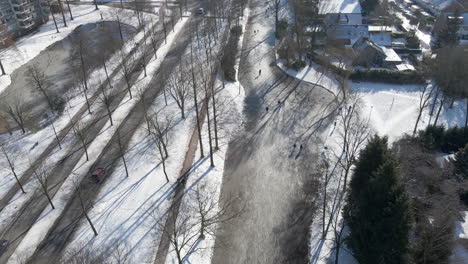 aerial of people skating on frozen river in a small dutch city in the netherlands