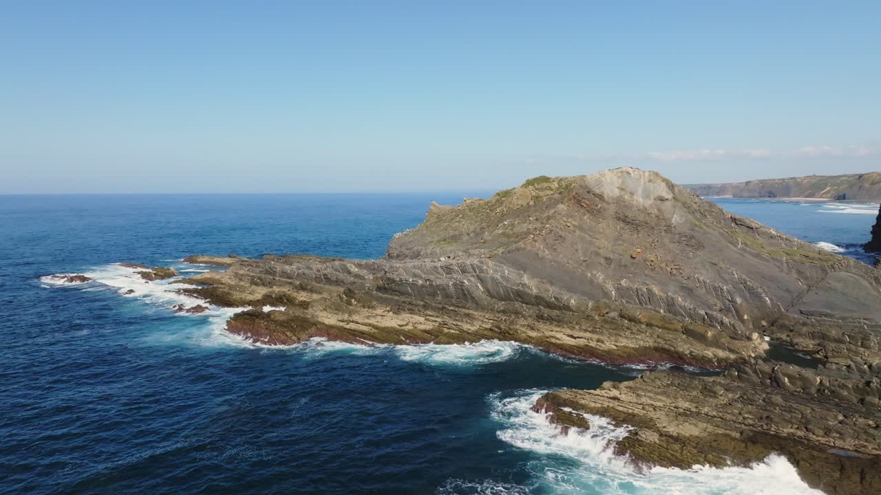 Waves crashing against the shore of Portugal, whenn suddenly a flock of birds take flight, creating a sense of freedom and majesty