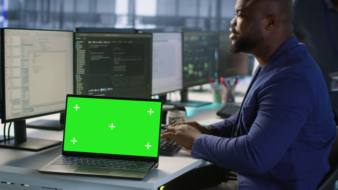 uomo che lavora su un portatile con uno schermo verde