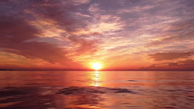 Breathtaking Sunset Over Tranquil Waters: A Scenic View of Dazzling Colors and Serene Reflections Captured at Dusk on the Calm Ocean Surface