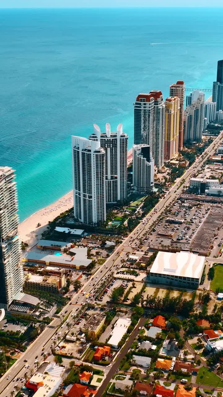 Luxusní Miami Beach z ptačí perspektivy za slunečného horkého dne. Nádherná modrá vodní krajina oceánu v pozadí. Vertikální video.