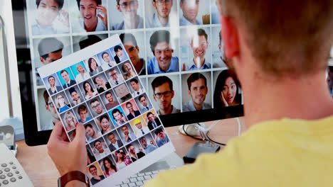 Male-executive-looking-photos-on-computer-at-desk-4k