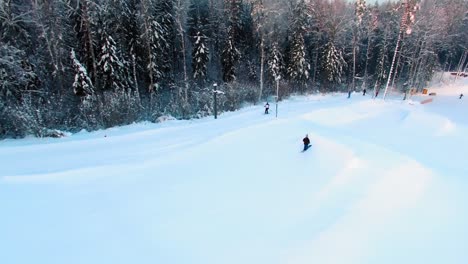 side aerial view of a skier jumping off a slope in a terrain park