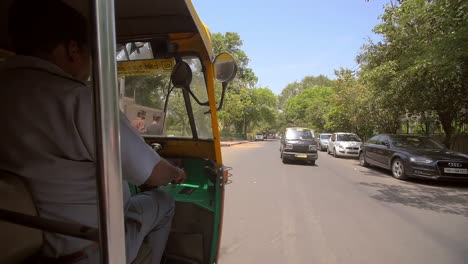 tuk tuk indio conduciendo por una carretera lateral