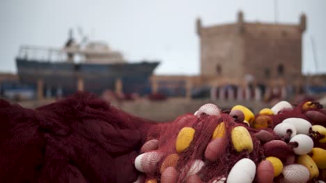 camera slides left with fish nets in focus and fishing boats out of focus