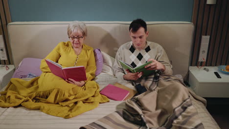 abuelo y nieto leyendo juntos en la cama
