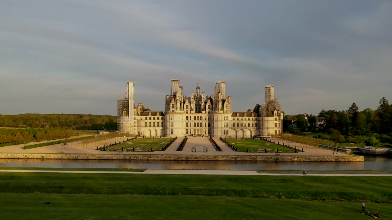 Dolly frontale, bassa quota, foresta, Castello di Chambord, erba verde, sole di fine giornata.