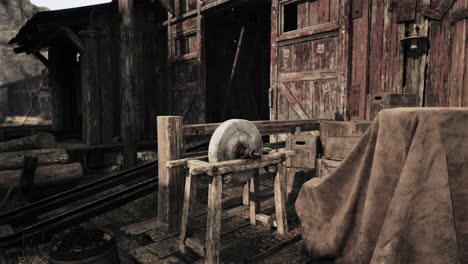 old, rusted grindstone in front of an abandoned shack