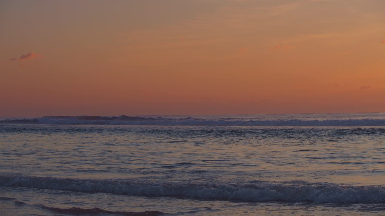 カラフルなオレンジ色の夕暮れの海を眺める