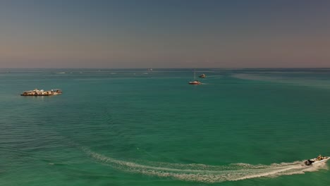 toma aérea volando hacia un catamarán navegando hacia la izquierda