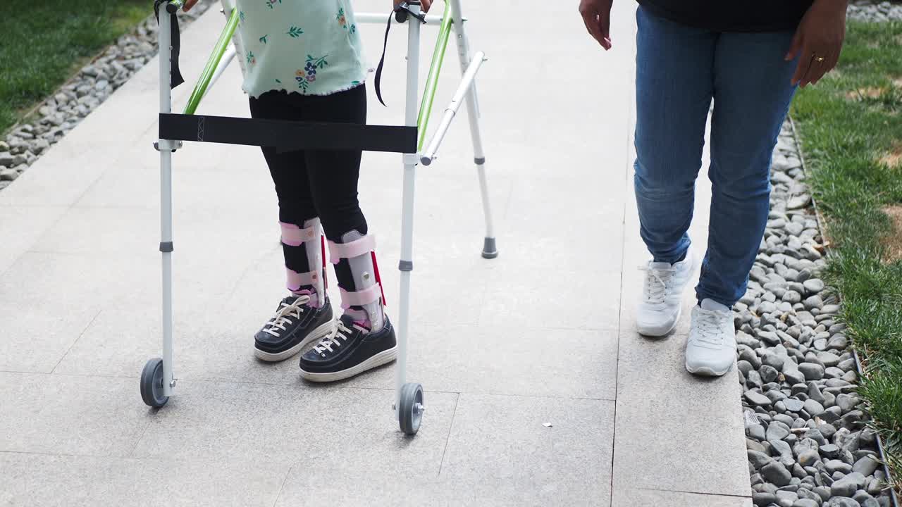 Little girl walking with a walker and a cast on her leg