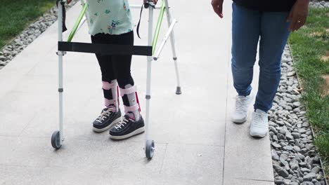 little girl walking with a walker and a cast on her leg