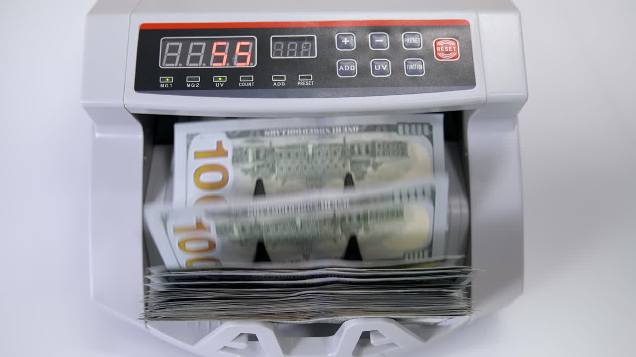 Automatic money counting in the machine. Electronic money machine is counting the dollar banknotes. Front view. Close-up.