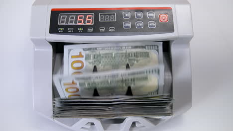 automatic money counting in the machine. electronic money machine is counting the dollar banknotes. front view. close-up.