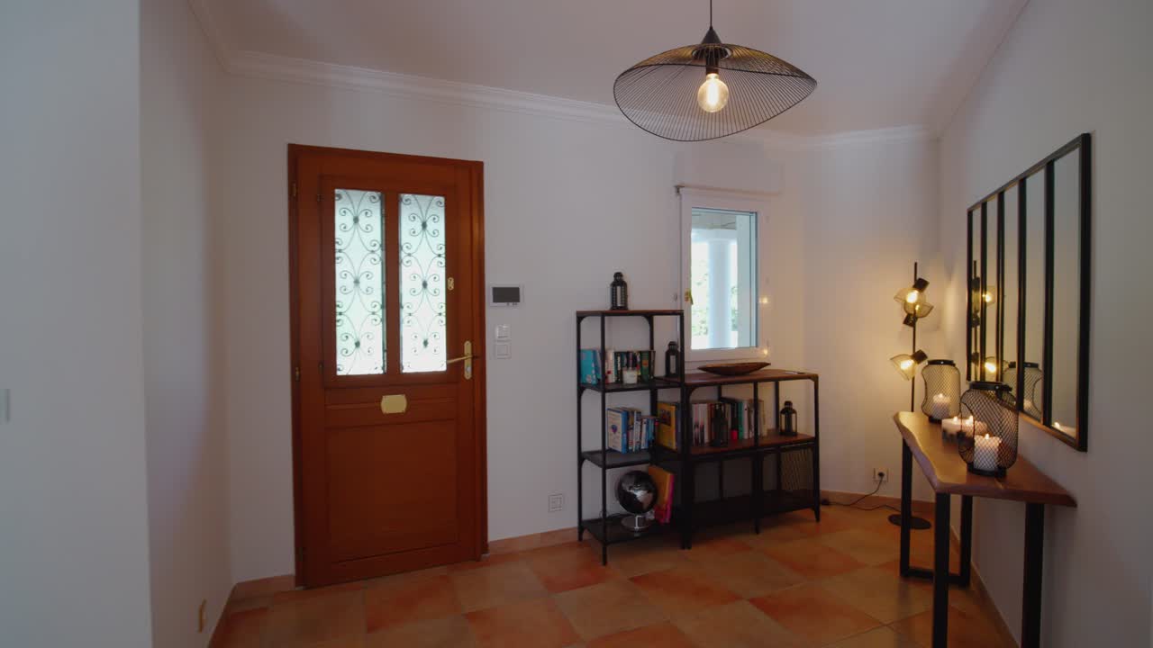 Ripresa lenta di un ingresso di casa con specchi e librerie.