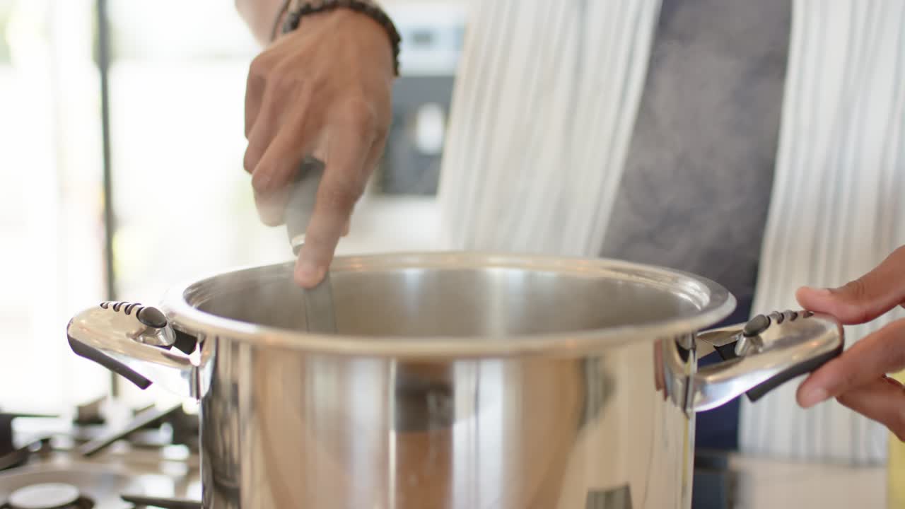 As gas burner is lighting, cook is stirring pot then is scooping spaghetti noodles for serving