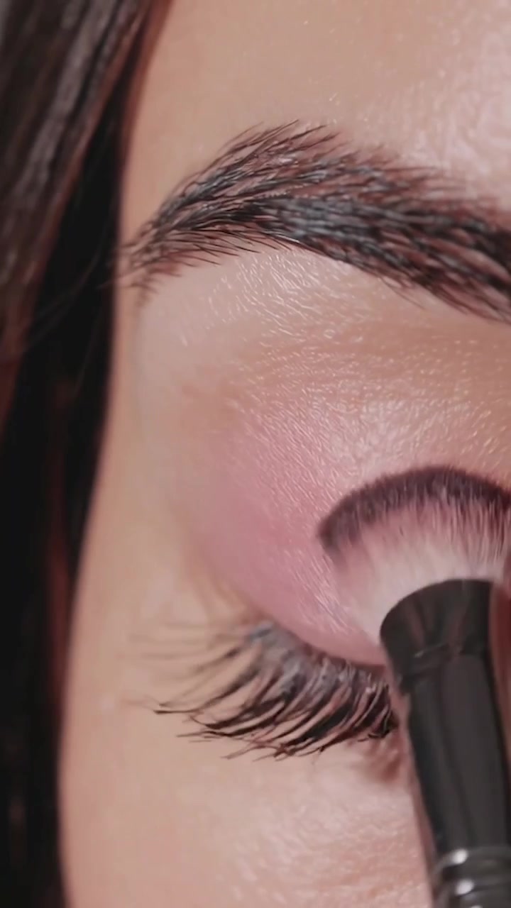 Close-up of Woman Applying Pink Eyeshadow with Makeup Brush