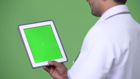 young handsome persian man doctor showing digital tablet