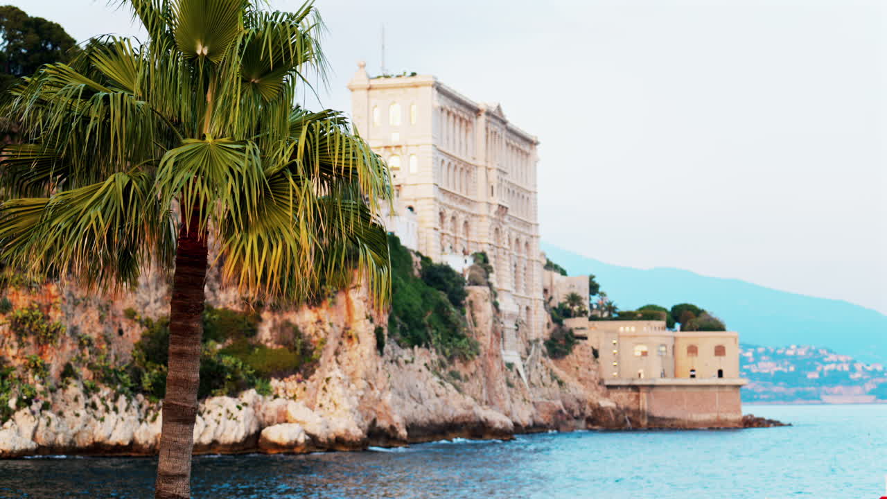 View of the The Oceanographic Museum of Monaco on the shore with the mountains on the background