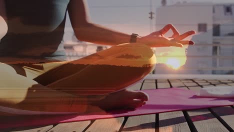 animation of glowing sunset over biracial woman practicing yoga