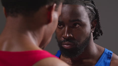 Close-Up-Of-Male-Boxer-And-Opponent-Standing-Face-To-Face-Before-Boxing-Match-Staring-At-Each-Other-1