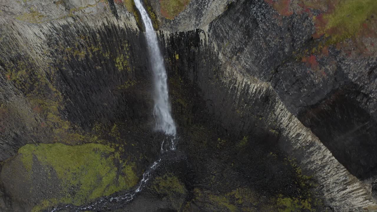 espectáculo aéreo de arriba hacia abajo de la caída de la cascada en el barranco de islandia durante el día - movimiento de inclinación hacia arriba