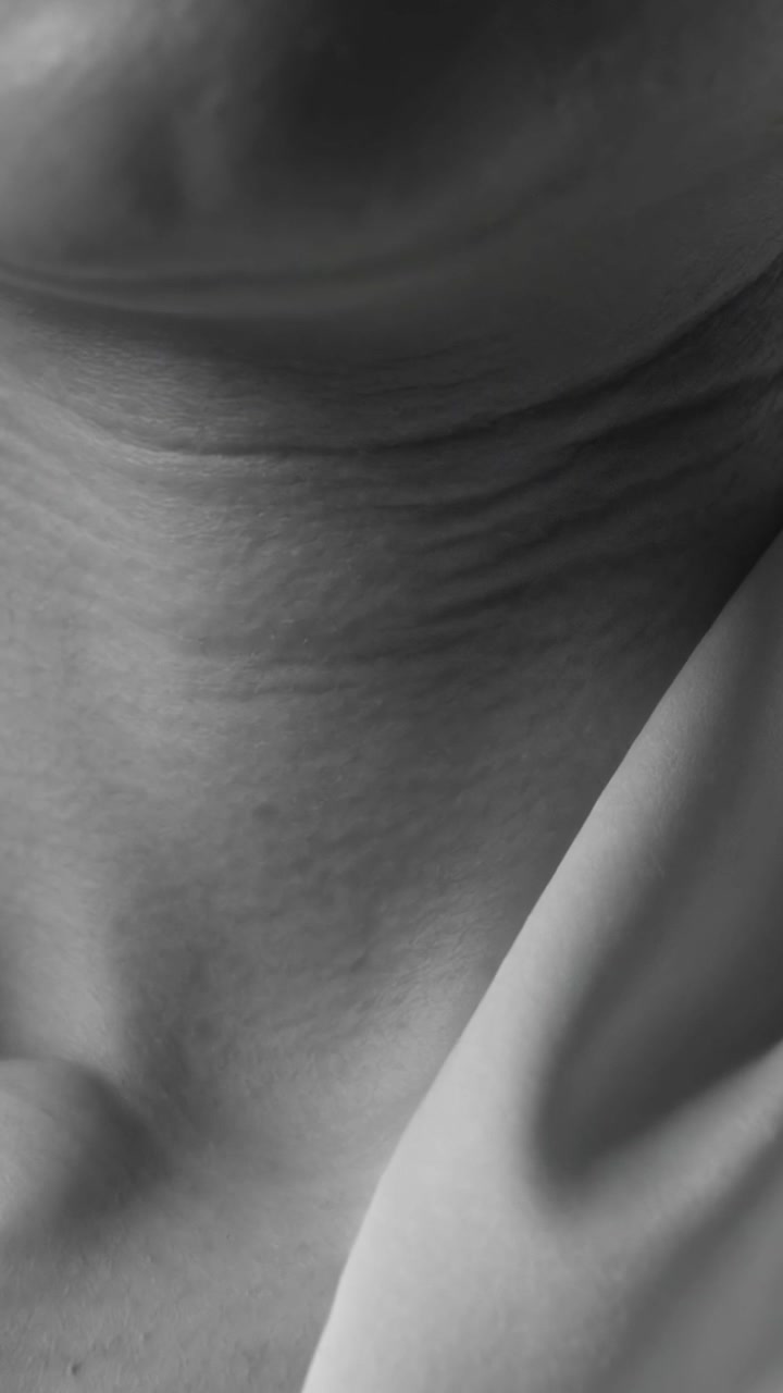 Vertical video: Showing woman's chin and neck moving while camera focusing at home, with blouse