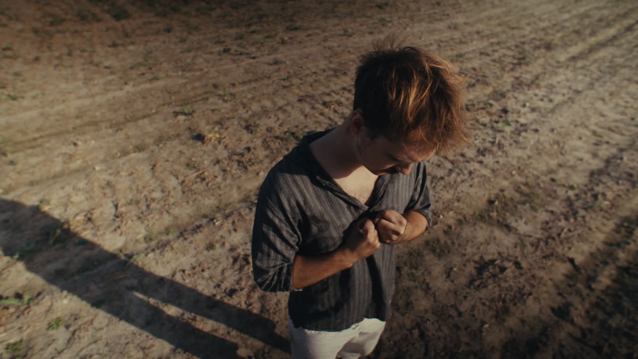 A man in a field looks thoughtful from a high angle