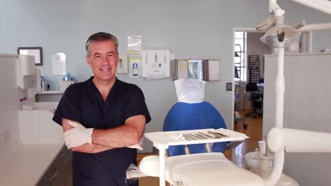 Smiling-dentist-standing-with-arms-crossed