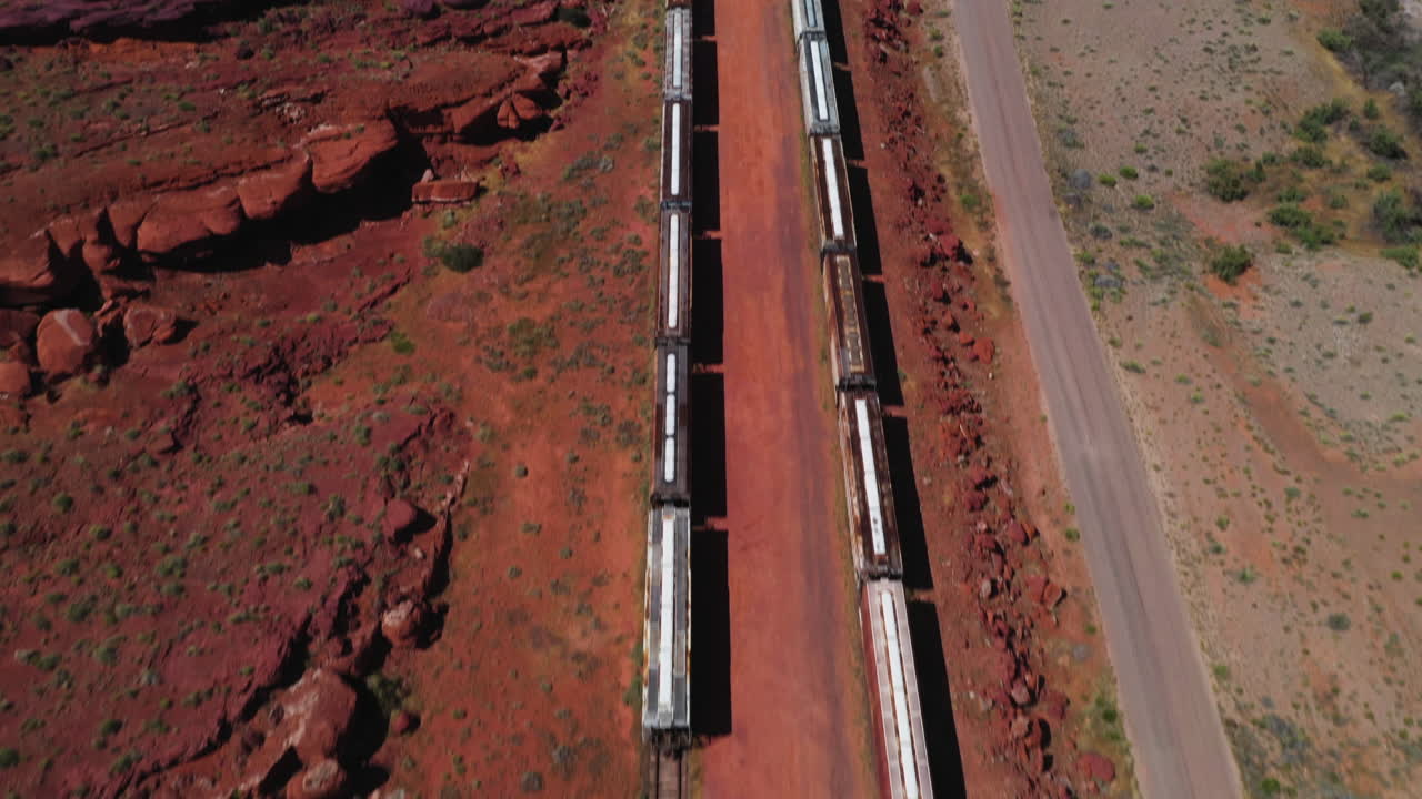 vista aérea inclinada sobre trenes estacionados en una estación del desierto, en el suroeste de los estados unidos