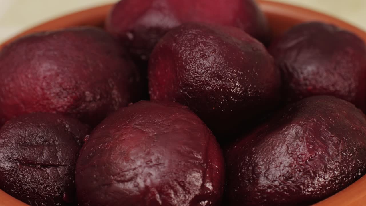 Raw peeled vegetable beet in plate on wooden table close-up. Preparing raw vagetables food for cooking. Cooking traditional Russian Borsch.