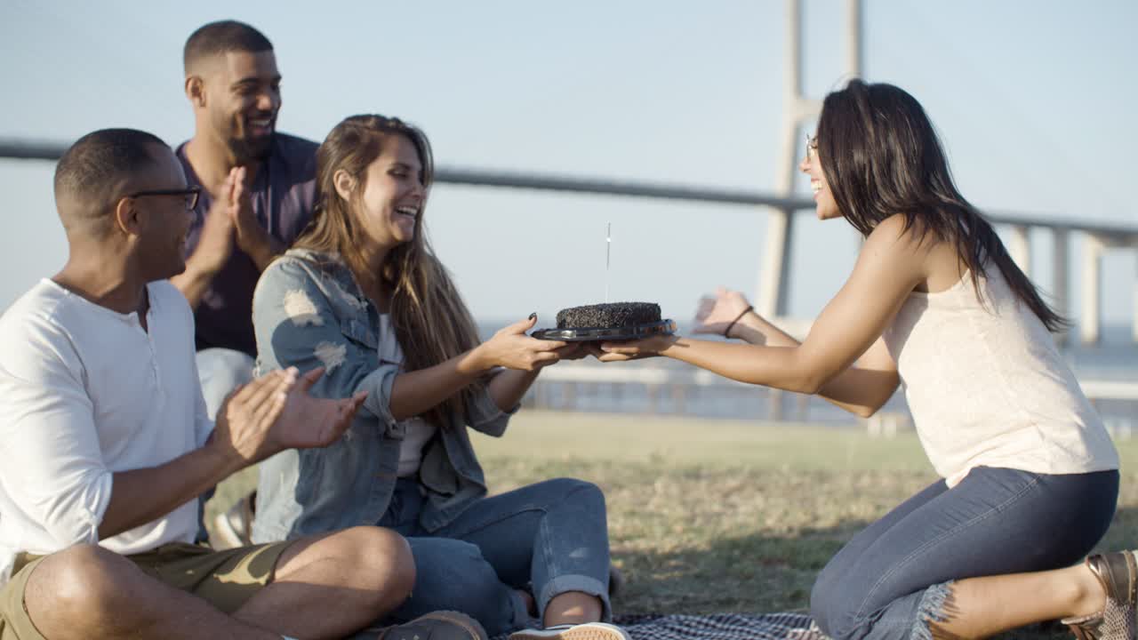hermosa mujer joven soplando chispas en el pastel
