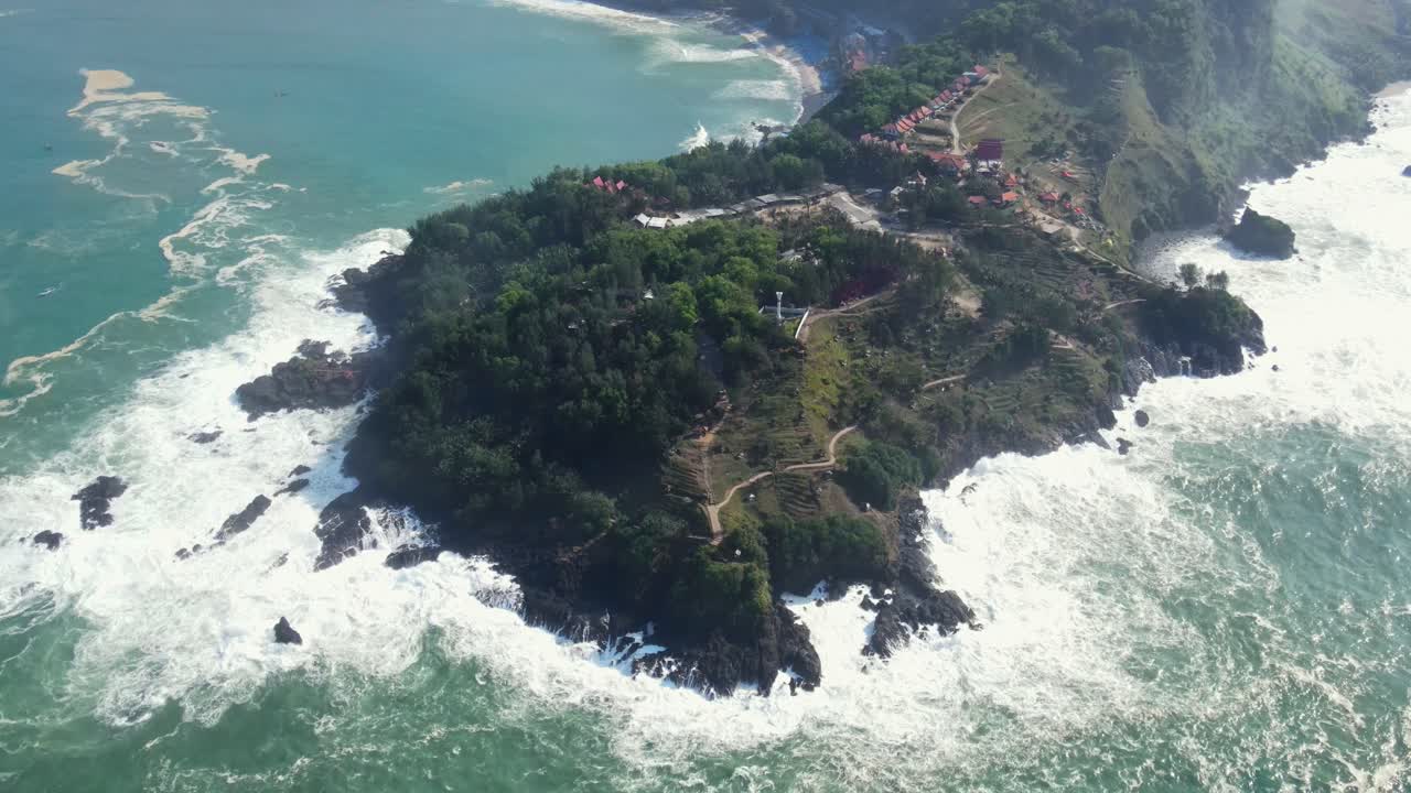 Aerial top down of scneic hill with crashing wavers against cliffs during sunny day,Central Java, Indonesia