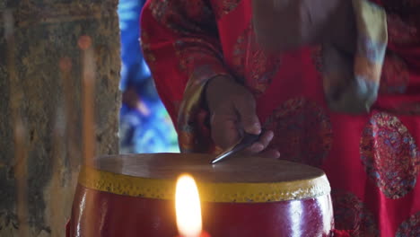 Man-playing-traditional-drum-during-ceremony-at-Whale-Temple