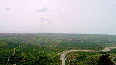 Cinematic-aerial-footage-of-a-river-flowing-through-a-valley-in-Sicily,-Italy,-Europe,-Drone