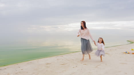 carefree mother and daughter three years running by the beach